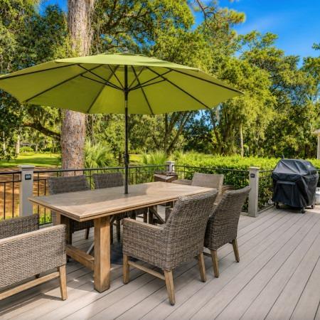 Fenced in backyard patio with a patio dining set and grill